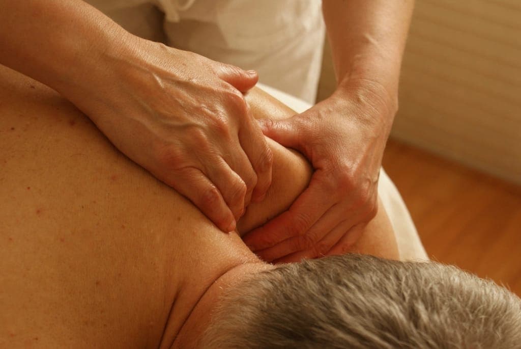 Kỹ thuật viên massage vùng vai gáy cho khách nam