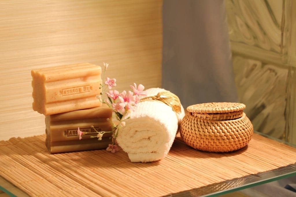 Bánh xà phòng, khăn cuộn và giỏ mây trên kệ spa