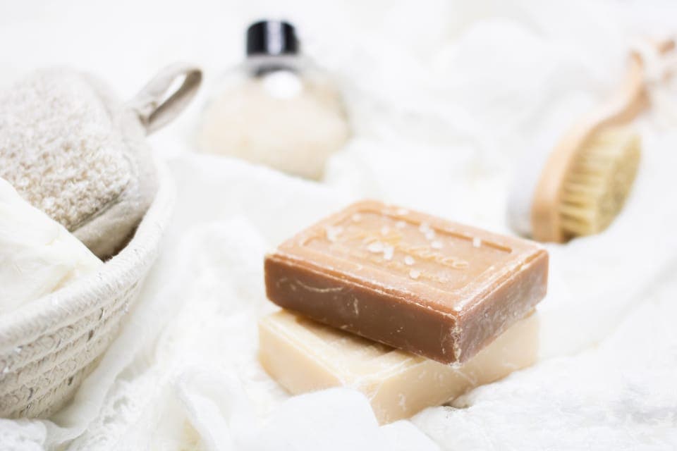 Bánh xà phòng thủ công trên khăn trắng cạnh bàn chải tắm
