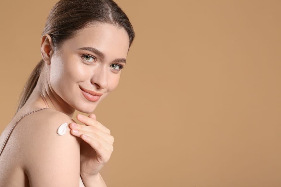 Người phụ nữ thoa kem dưỡng lên vai