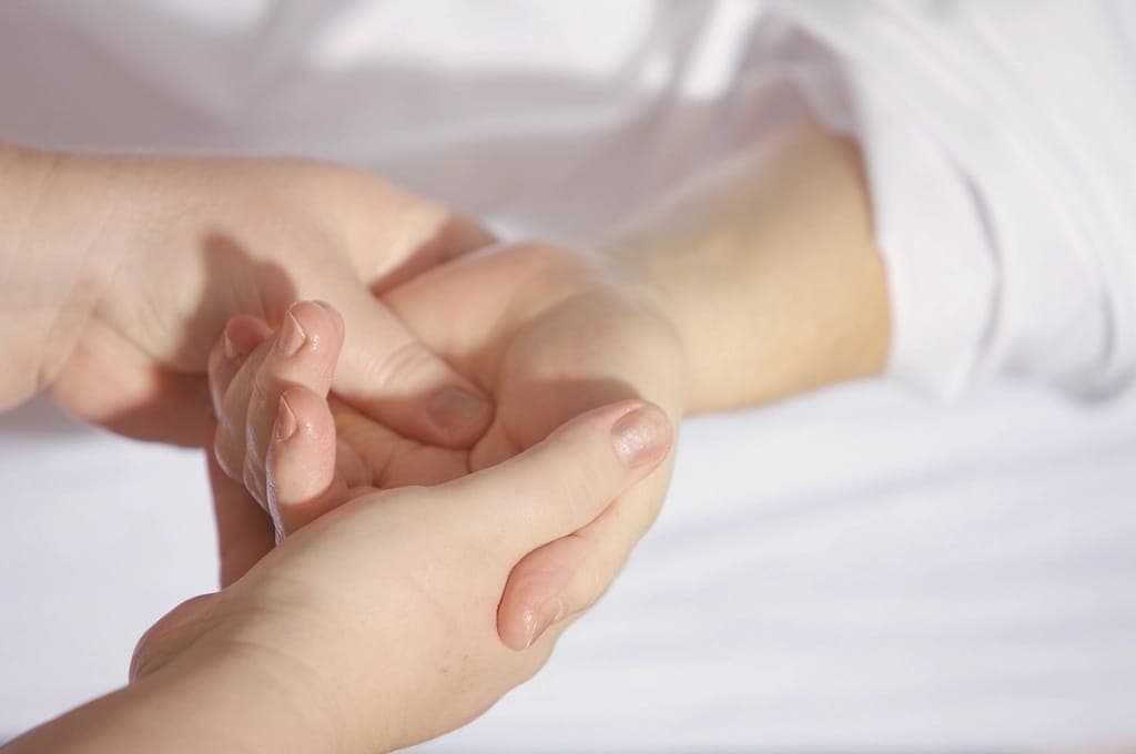 Kỹ thuật viên xoa bóp bàn tay và cẳng tay khách