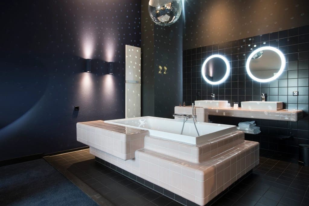 Phòng tắm spa hiện đại với bồn tắm và gương đèn tròn