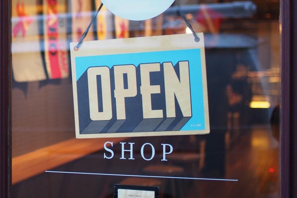 Biển OPEN treo sau cửa kính một cửa hàng