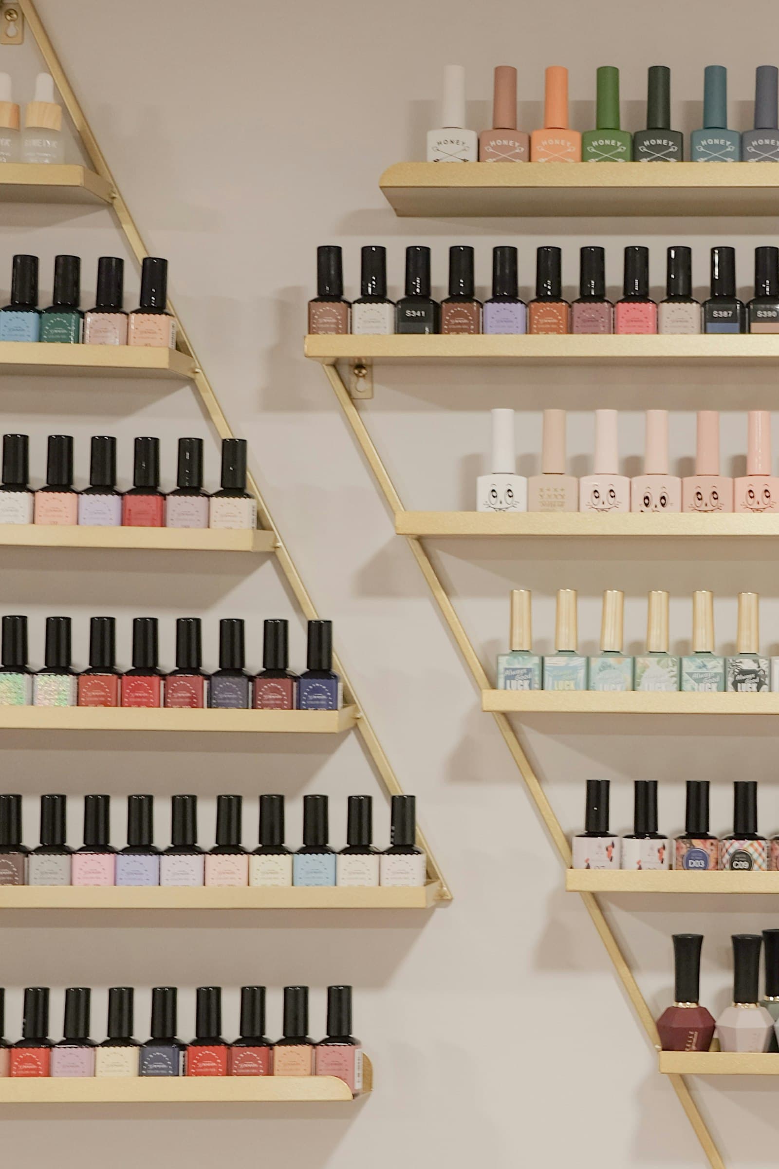 Kệ chai sơn gel xếp theo màu trong tiệm nail