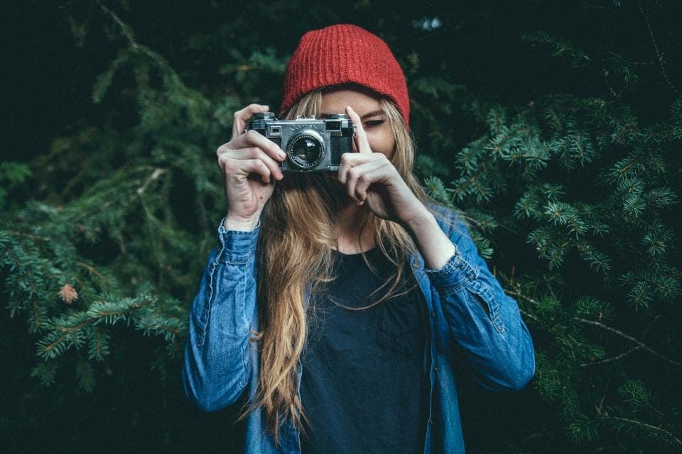 Người đội mũ len đỏ chụp ảnh bằng máy ảnh