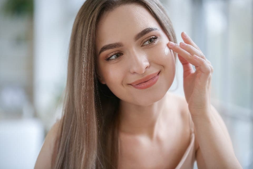 Người phụ nữ thoa kem lên gò má