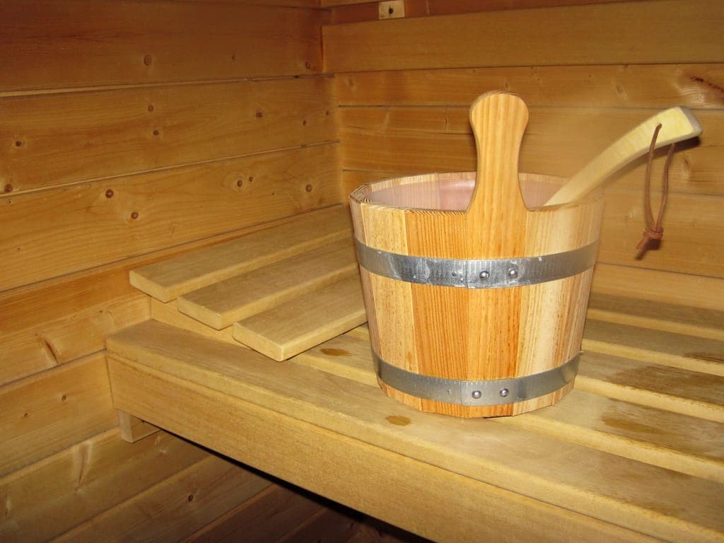 Xô và gáo gỗ đặt trên ghế trong phòng xông hơi khô