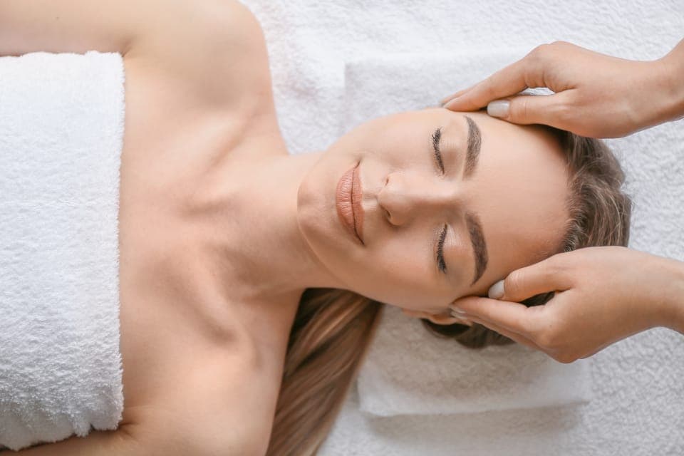 Khách nhắm mắt thư giãn khi được massage thái dương