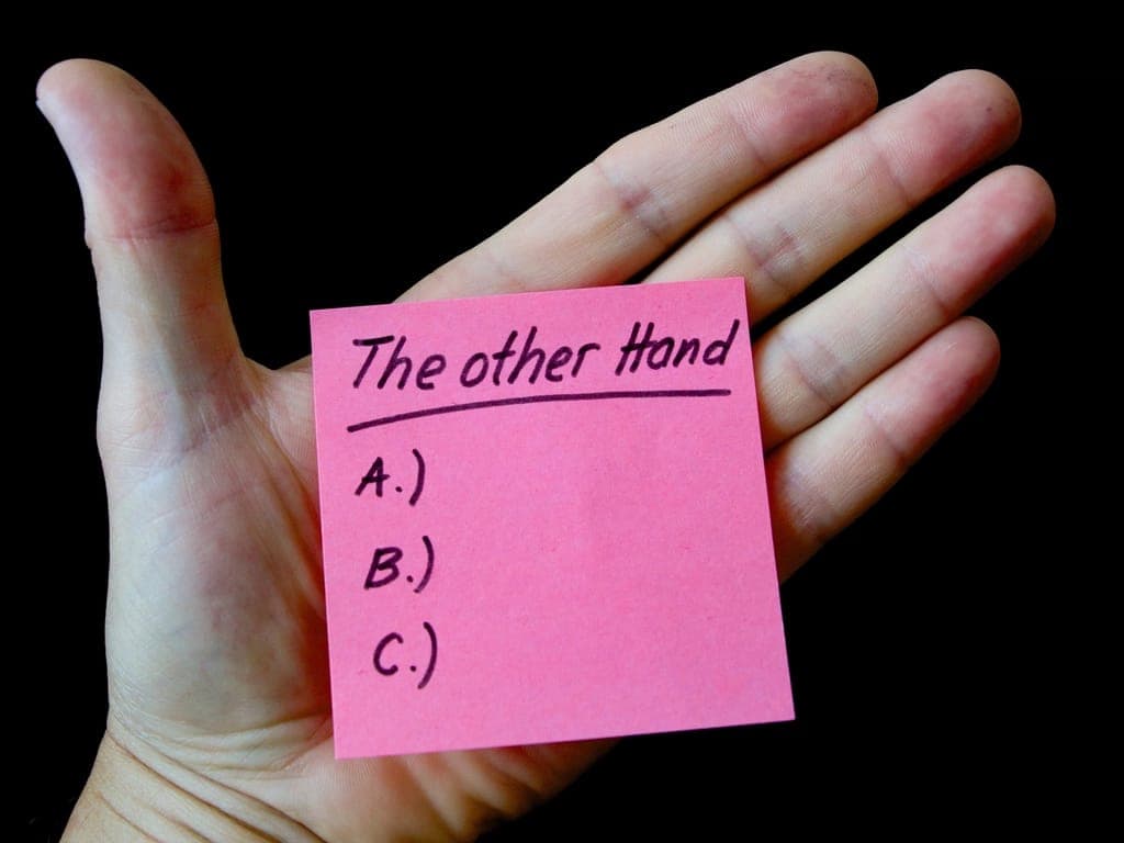 Tờ giấy nhớ màu hồng ghi các lựa chọn A, B, C trên lòng bàn tay