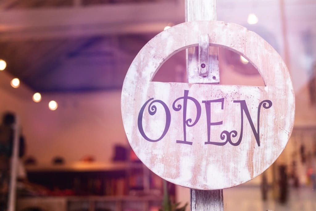 Biển gỗ chữ OPEN treo trước cửa tiệm