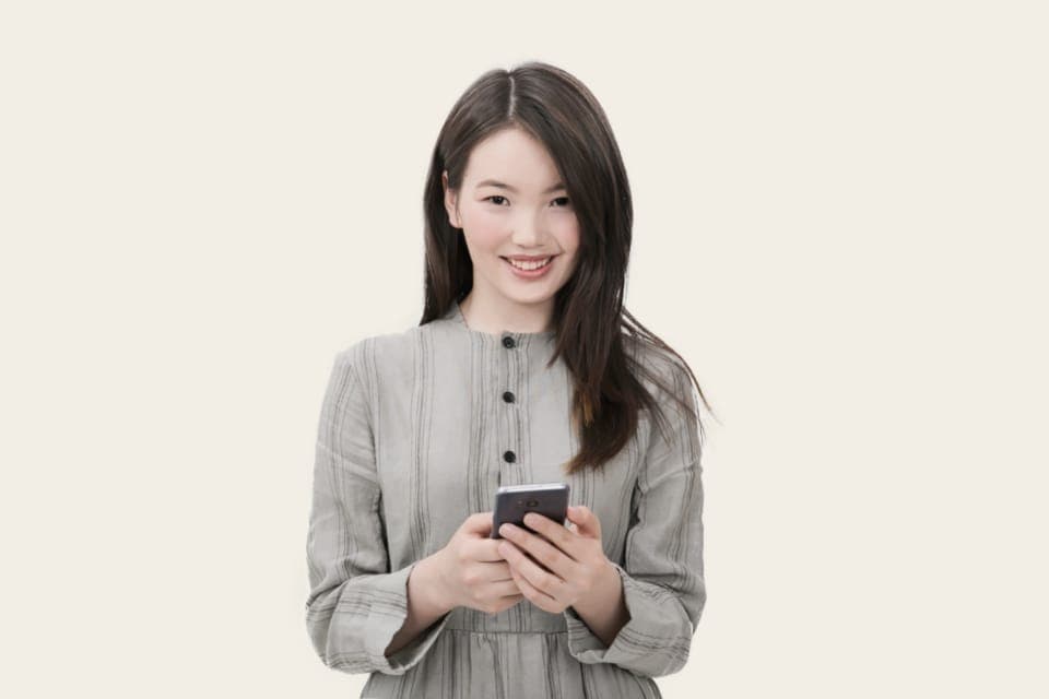 Người phụ nữ mỉm cười cầm điện thoại