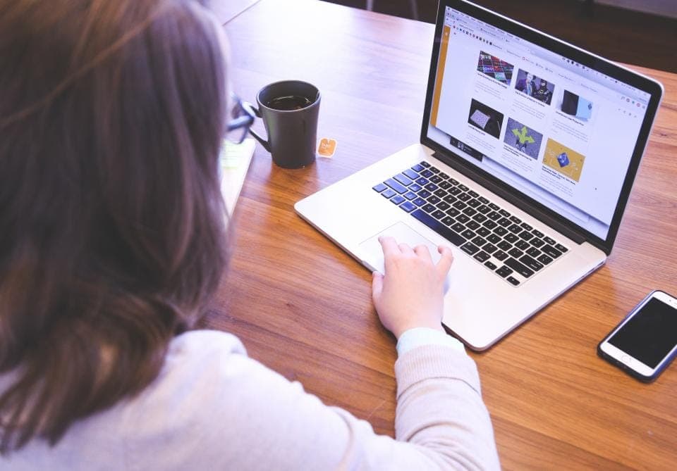 Người dùng máy tính xách tay xem trang web bên tách cà phê