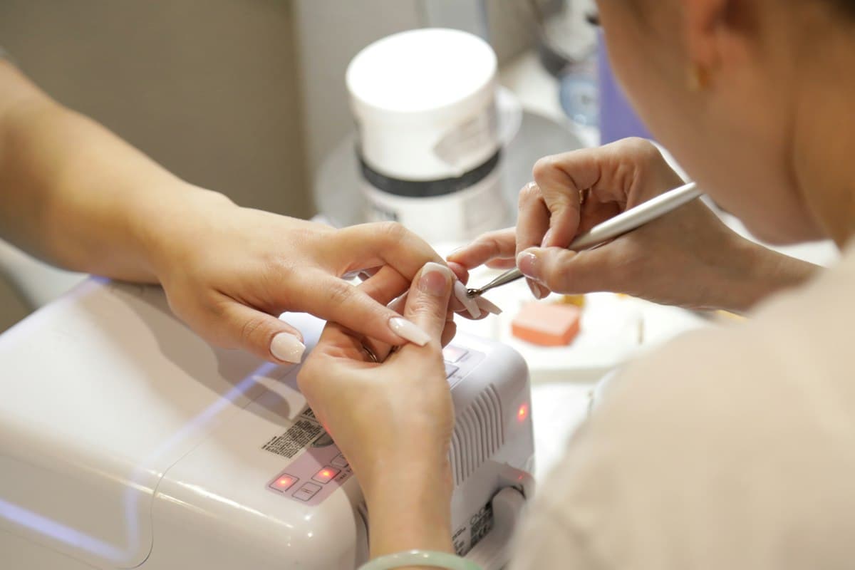 Kỹ thuật viên làm móng cho khách tại tiệm nail