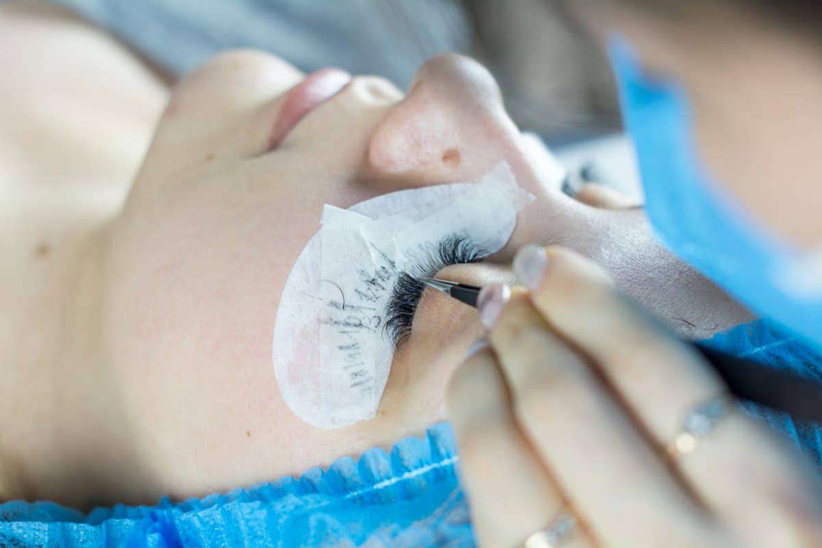 Kỹ thuật viên nối mi cho khách bằng nhíp